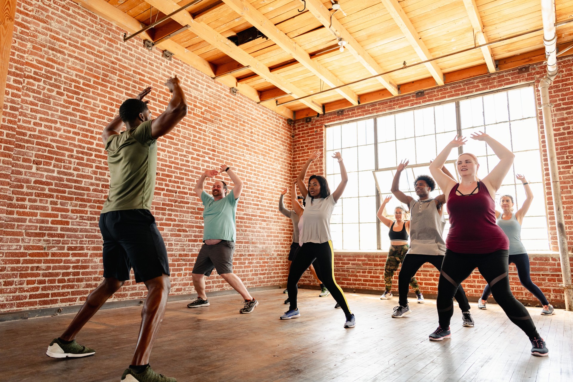 Group fitness class with diverse participants in a studio.